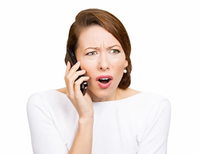 Closeup portrait young angry business woman, corporate employee talking on cell phone, having unpleasant, bad conversation, isolated white background. Negative emotions, facial expressions, reaction