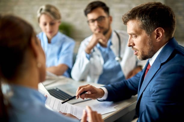 An insurance agent showing coverage options to a medical board.