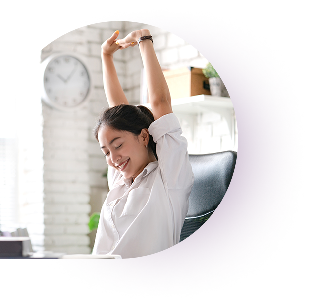 A healthcare professional liability insurance agent smiling while stretching and relaxing at her desk. 