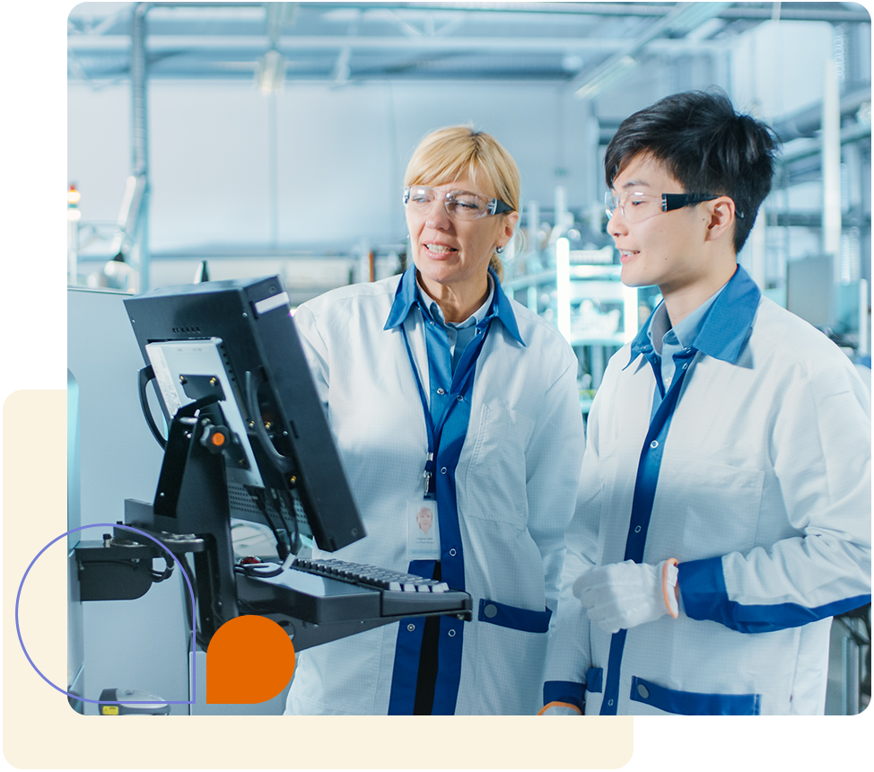Two life sciences product engineers in a laboratory, smiling, working on a medical device.